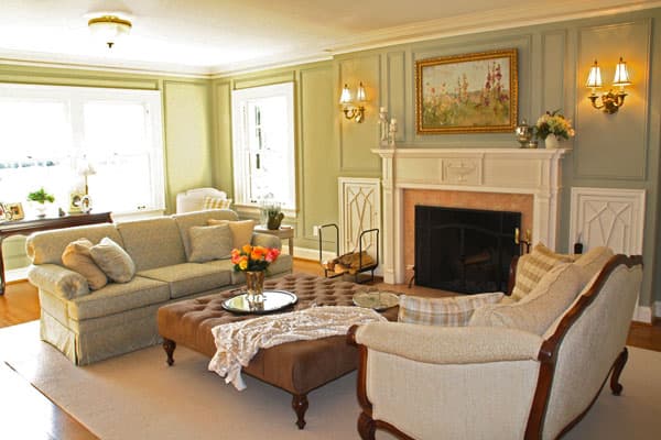 Lit candles create an inviting ambience. The soft fur throw and coral roses, placed on a mirrored tray, add warmth to this stunning traditional Georgian-style home.